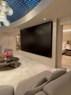 a living room filled with furniture and a flat screen tv mounted to the wall above it