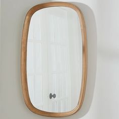 an oval mirror hanging on the wall