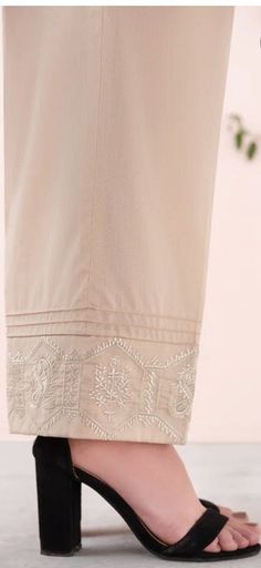 Look your best by wearing this embroidered trousers to pair with any dress. Detail: - Color: Gold - Fabric: Cambric - Loose Straight Trousers with Pintucks - Embroidered Hem Beige Cotton Pants With Floral Embroidery, Embroidered Straight Beige Pants, Beige Embroidered Straight Pants, Summer Embroidered Beige Pants, Elegant Chikankari Embroidered Bottoms For Summer, Elegant Resham Embroidery Bottoms For Spring, Elegant Resham Embroidered Bottoms For Spring, Elegant Summer Bottoms With Chikankari Embroidery, Elegant Bottoms With Resham Embroidery For Spring