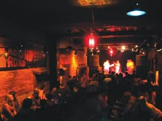 a group of people sitting around in a room with lights on the ceiling and brick walls