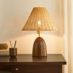 a wooden table with a lamp on top of it and a pen holder next to it