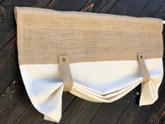 a white and beige purse sitting on top of a wooden floor