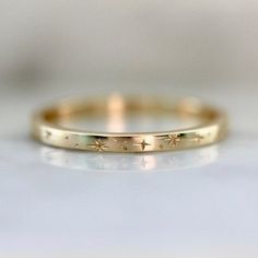 Why I Love It:A modern take on a Mid-Century design in this star-inspired engraved gold star band. Swift and careful hand movements create this motif of stars, the engraved texture of precise detail, and extraordinary design in your choice of golds. The Details:Band Width is Approx. 1.80 mm Band Height is Approx. 1.30 mmMade to order in your size, please allow approximatelyBands are all hand engraved and subtle variations may occurThis page price only for one ring, if you like to order a set rin Orion Star, Midi Rings Gold, Handmade Gold Ring, Alternative Wedding Rings, Engraved Ring, Solid Gold Band, Wedding Rings Unique, Diamond Shop, Star Ring