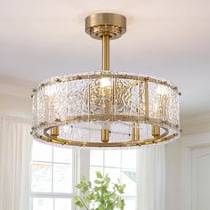 a chandelier hanging from the ceiling in a room with white walls and windows