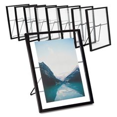 four black frames with mountains and water in the middle one is hanging upside down on a white background