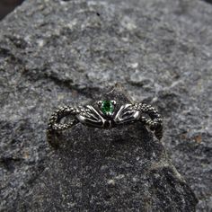 This unique silver engagement ring features a stunning design with twin snakes wrapping around each other, facing each other, and holding a sparkling emerald between their heads. The intricate detailing of the snakes' scales and the vivid green of the emerald make this ring a truly eye-catching piece of jewelry.  Characteristics: Metal - Recycled solid sterling silver  Stone - Cubic Zirconia Finish - Oxidized. View all silver gothic rings: https://www.etsy.com/shop/TinyShinyJewel?ref=seller-platform-mcnav&section_id=42765371 Care instructions: To care for the ring, avoid contact with water and chemicals such as perfumes and lotions. When the ring is not in use, store it in a dry, cool place to prevent tarnishing. Additional information:  ✦ All rings are made to order. An average turnaround Silver Fantasy Rings For Collectors, Mystical Gemstone Rings For Collectors, Mystical Green Gemstone Jewelry, Mystical Collectible Gemstone Rings, Sterling Silver Fantasy Style Promise Ring, Sterling Silver Fantasy Rings As Gift, Silver Fantasy Rings For Anniversary, Fantasy Silver Rings For Anniversary, Fantasy Style Silver Ring For Anniversary