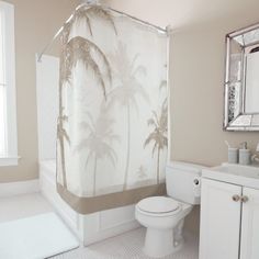 a bathroom with a palm tree shower curtain