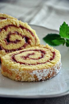 two pastries sitting on top of a white plate next to a green sprig