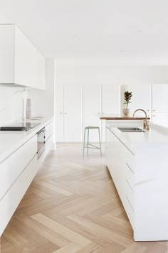 a white kitchen with wooden floors and an island in the middle is featured on instagram