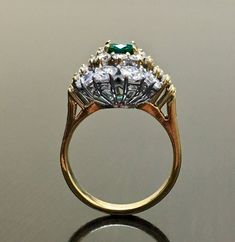 DeKara Designs Classic Handmade Art Deco Oval Emerald and Diamond Ring. Metal- 18K Yellow Gold, .750 Stones- 1 Oval Natural Green Colombian Emerald 0.81 carats, 22 Round Diamonds, 10 Baguette Diamonds, F-G Color VS2 Clarity 2.85 Carats. Art Deco inspired 18K Yellow Gold Diamond Colombian Emerald Engagement Ring. The ring features a beautiful green Colombian Emerald, that is truly an exceptional color and quality. There are five baguette diamonds on each side of the emerald that are prong set, an Luxury Gold Emerald Round Ring, Luxury Gold Emerald Ring, Classic Gold Emerald Ring With Halo Setting, Luxury Gold Emerald Ring For Wedding, Elegant Gold Emerald Ring For Wedding, Elegant Gold Emerald Wedding Ring, Luxury Gold Emerald Ring With Halo Setting, Exquisite Gold Emerald Ring For Anniversary, Formal Gold Rings With Emerald