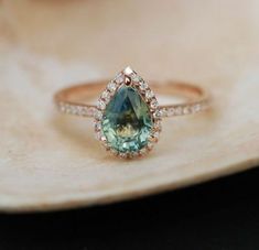 a close up view of a ring with an aqua and white stone in the center