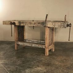 an old wooden table with two tools on it's legs and one piece of wood sticking out of the top