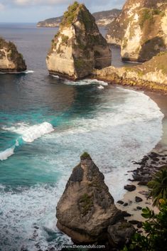 an ocean view with rocks and waves crashing in the water