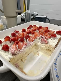 a large white cake with strawberries on top is in a pan and ready to be eaten