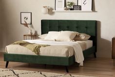 a bed with green headboard and foot board in a white walled room next to a wooden dresser