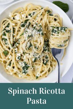 spinach ricotta pasta on a white plate with a fork