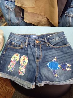 the shorts are decorated with flowers and flip flops on them, but they have been cut off