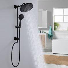 a shower head with the water running down it's side and a bathtub in the background