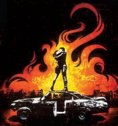 a movie poster with a man standing on top of a car in front of flames