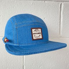 "Handmade cap with pencil holder✏️ ✎DETAILS: 5 panel cap is handmade from 10 oz indigo denim ( milled in the USA). Sewn with golden heavy duty top stitch thread. Patch, brim and hardware made in the USA. The brim is not a bought plastic insert. Brims are handmade here in house, they are shorter and softer than typical hats. They are super comfortable yet still completely hand washable and incredible durable. Hand built by two human makers ( apes/April & bird/Rich) with love, care and pride here Adjustable Denim Cap, Denim Cap For Outdoor Use, Denim Cap For Outdoor, Denim Snapback Hat, Blue Adjustable Flat Cap, Adjustable Blue Flat Cap, Casual Blue 5-panel Fitted Hat, Adjustable Denim Baseball Cap With Flat Bill, Adjustable Denim Hat For Outdoor