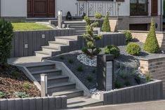 a house with stone steps leading up to the front door and landscaping on either side