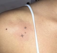 the back of a woman's shoulder with three small stars on her left side