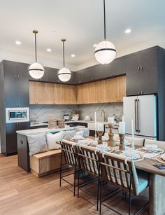 a kitchen with an island and dining table in front of the stove, oven and microwave