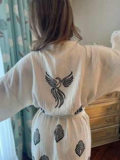 "Beautiful handmade long white Phoenix bird celestial print kimono robe, designed with cotton fabric, it flows as you move for a comfortable wear. Beach cover up, a kimono with Phoenix bird.  This is a lovely, good-quality kimono, with traditional breathable kimono sleeves.        A belt that ties around the waist. Great to wear around the house, on beaches, or to dress up with some jeans & a T-shirt, covering up on the beach with a swimsuit.         We love kimonos as they are so versatile. They also make really special & unique birthday, valentines Day, Christmas gifts, and Mother's Day gifts. The perfect combination of comfort and style, this kimono is a great addition to your new season wardrobe.    Cotton Fabric and Handmade      Length from shoulder: 75 CM Width: 130 CM Kimono Size: Traditional White Kimono For Loungewear, White Traditional Kimono For Loungewear, White Long Kimono For Loungewear, White Bohemian Long Kimono, White Long Bohemian Kimono, Printed White Kimono For Festival, White Bohemian Cotton Kimono, White Printed Kimono For Loungewear, White Printed Kimono For Festival