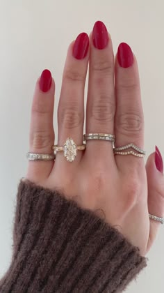 a woman's hand with three different rings on it and one ring in the middle