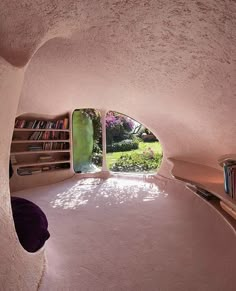 a room with a round bed and bookshelves in the corner that is shaped like a house