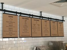 the menus are hanging on the wall above the coffee shop's counter top