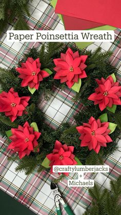 paper poinsettia wreath with green leaves and red flowers on plaid table cloth