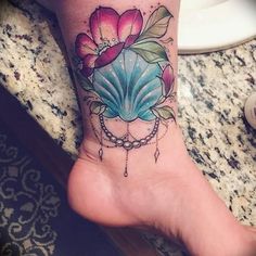 a woman's foot with a flower tattoo on it