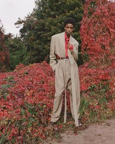 a man standing in front of some bushes