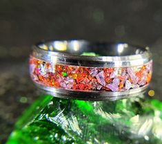 a wedding band with red and orange glitter on it