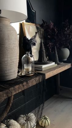 a table with some pumpkins on it and a lamp in the corner next to it