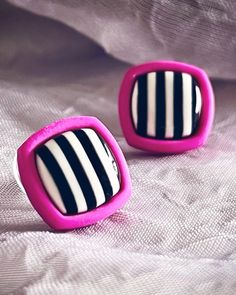 two small black and white striped buttons on a bed