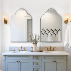 a bathroom with two sinks and mirrors on the wall