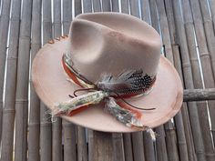 Decorated wide brimmed fedora hat will complement any outfit! With a western boho style, this hat can be for both casual and formal.  This hat has been burnt and hand stitched to give it a unique distressed appearance . Hand made hat-bands include a one of a kind design using an assortment of fabrics, premium leather and real feathers.  Please feel free to message me with any customization requests. These are quite literally completely customizable. One Size Fits MOST. 22 3/8 circumference inner Bohemian Beige Felt Hat For Kentucky Derby, Beige Bohemian Felt Hat For Kentucky Derby, Bohemian Beige Fedora For Kentucky Derby, Country Style Hat Bands For Fall Festival, Bohemian Felt Hat For Ranch, Bohemian Flat Brim Felt Hat For Ranch, Bohemian Brimmed Felt Hat For Ranch, Beige Bohemian Fedora For Kentucky Derby, Southwestern Style Fall Hats For Country Events