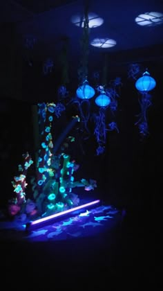 a bunch of jellyfish in the dark with some blue lights on their heads and legs