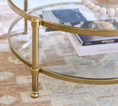 a glass table topped with a book and a beaded necklace on top of it