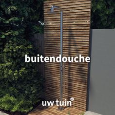 an outdoor shower in front of a wooden wall and trees with the words, buttendouche uw tuin