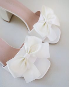 Classic satin slip on block heel sandals for casual and dressy look, adorned with a satin bow at the front that adds a romantic touch. Simple and easy wear for bridal wear, bridesmaids, holiday party, wedding parties, and any special occasions. DETAILS: HEEL HEIGHT: 2.5 InchesCOLORS AVAILABLE: Ivory and WhiteUPPER: Synthetic upper and liningMATERIALS: Manmade outsole Spring Open Toe Sandals With Satin Bow, Summer Sandals With Satin Bow And Open Heel, Spring Evening Wedding Shoes With Satin Bow, Low Heel Heels With Satin Bow For Spring, Spring Low Heel With Satin Bow, Spring Low Heel Heels With Satin Bow, Summer Sandals With Satin Bow, Summer Sandals With Padded Heel For Wedding Guest, Party Open Toe Block Heels With Bow