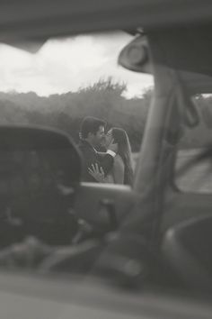 a man and woman kissing in the back of a car