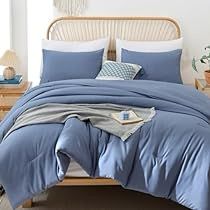 a bed with blue sheets and pillows in a room