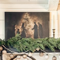 a fireplace mantle decorated with christmas garland and lights