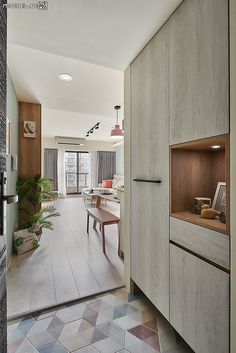 an open kitchen and dining area with wooden cabinets, tile flooring and potted plants