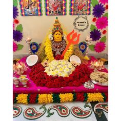 there is a statue in the middle of a table with flowers and plates on it