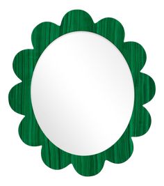 a green flower shaped mirror sitting on top of a white wall mounted shelf next to a wooden frame