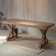 a wooden table sitting on top of a rug next to a potted green plant